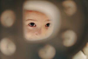 Ein Kind was durch ein Loch schaut
