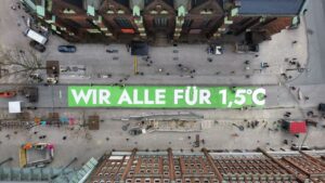 Demo von Fridays for Future für 1,5 Grad Klimaziel. Ein Banner von oben fotografiert zwischen Hochhäusern.