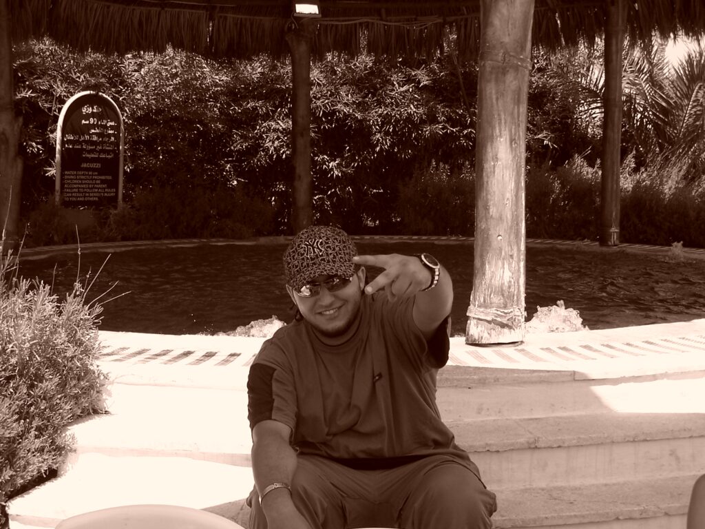 Der Rapper Murder Eyez strahlt und macht ein Peace-Zeichen in die Kamera.