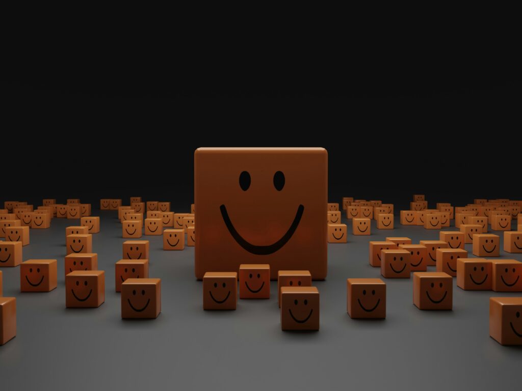 Ein dunkler Raum mit vielen kleinen quadratischen Blöcken, auf denen immer der gleiche Smiley zu sehen ist. Ist der Mitte ist der gleiche Block in groß.
