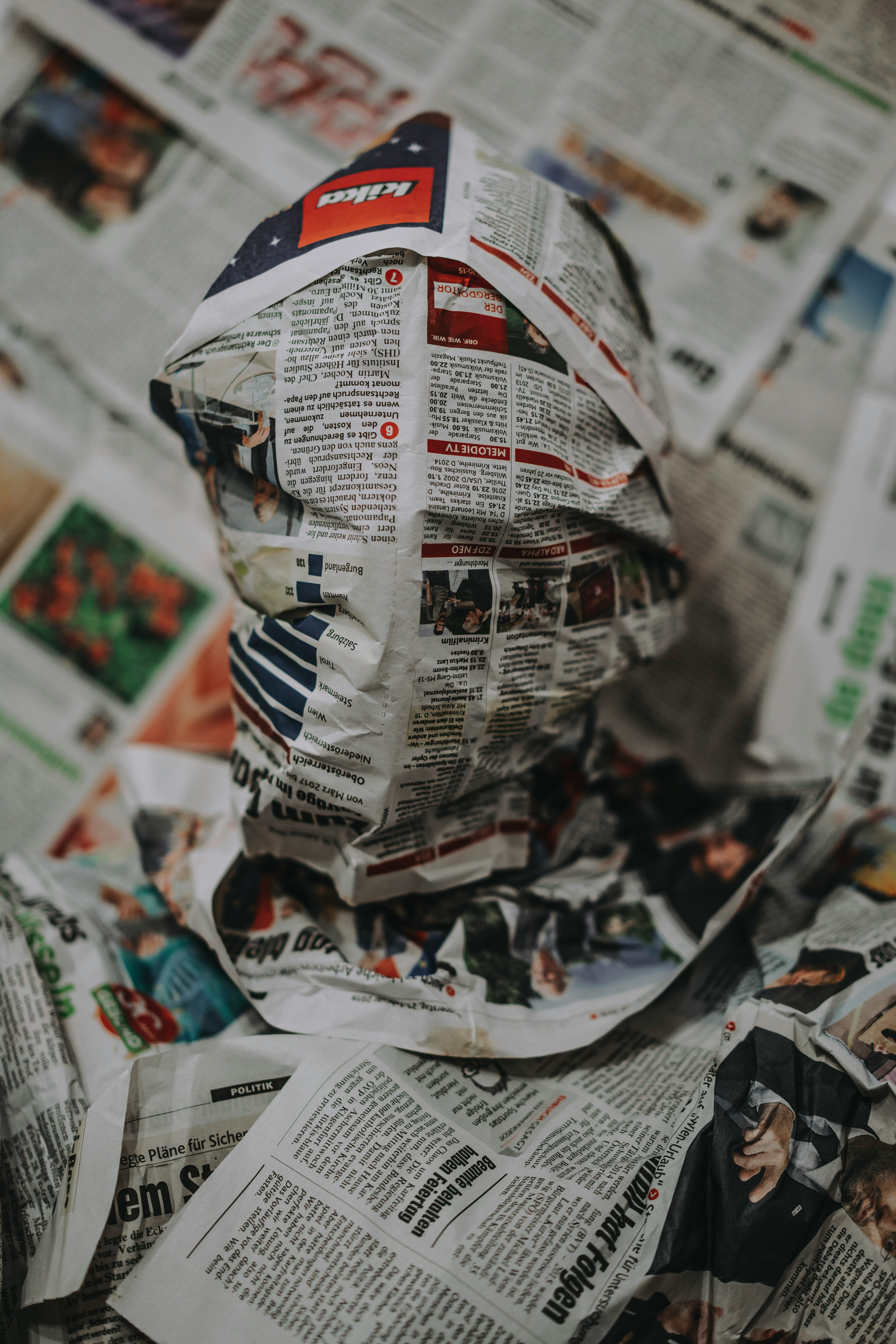 Eine Person, die in Zeitungspapier geh&uuml;llt ist