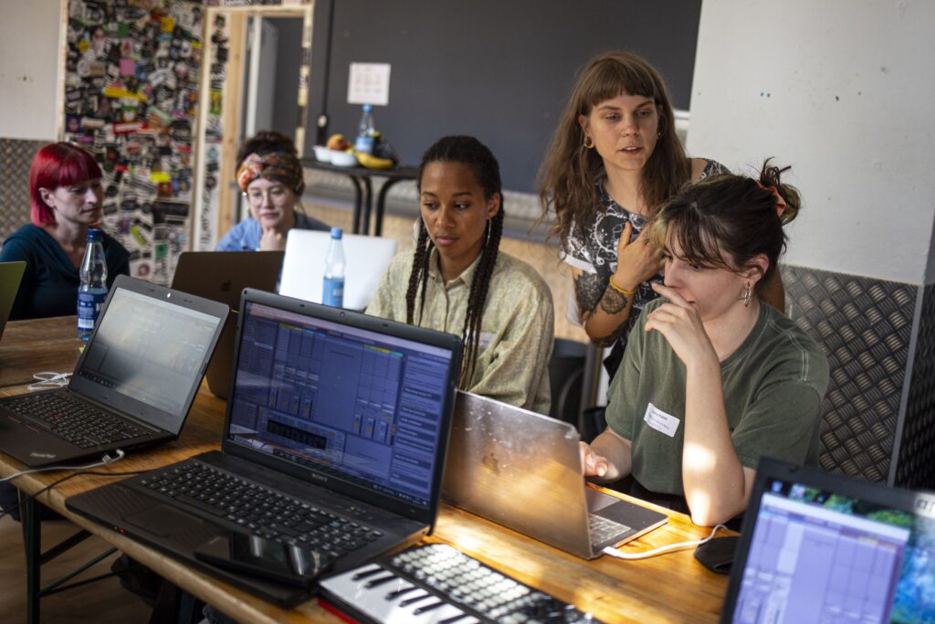 Frauen sitzen vor Laptops