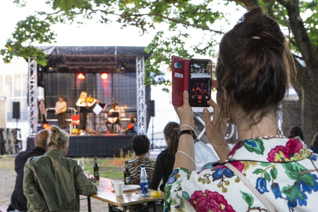 Frau fotografiert einen Auftritt auf einer B&uuml;hne