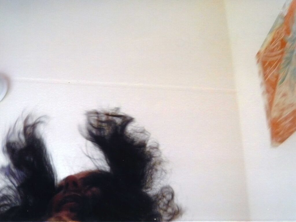 Eine Person ist verschwommen und angeschnitten von unten zu sehen. Die Haare fliegen durch die Luft.