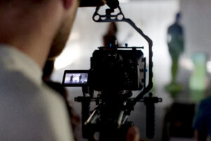 Eine professionelle Filmkamera, die auf eine laufende Szene gerichtet ist