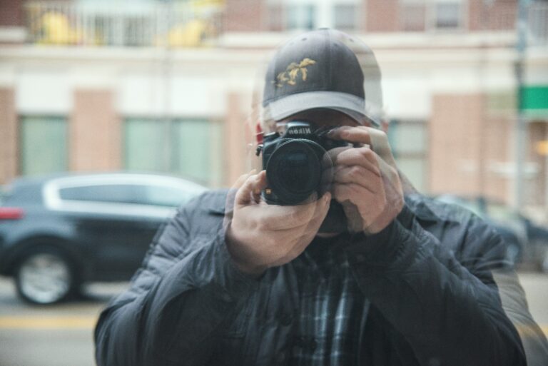 Eine Person fotografiert sich in der Scheibe, das Bild ist verschwommen