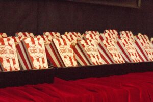 In Reihe angeordnete und gefüllte Popcorntüten auf rotem Stoff