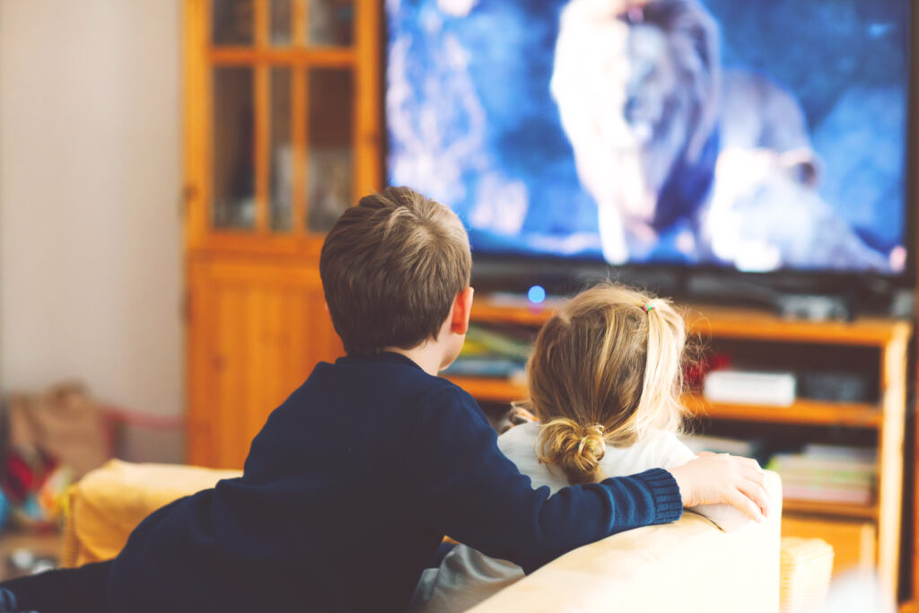 Zwei Kinder, die auf der Couch einen Film schauen