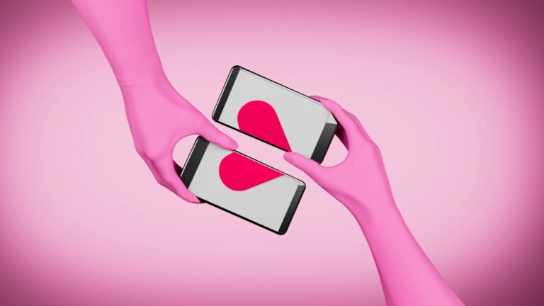 Zwei rosa Arme, die in der Mitte des Bildes zwei Handys nebeneinander halten, sodass die Bildschirme sich zu einem roten Herz ergänzen