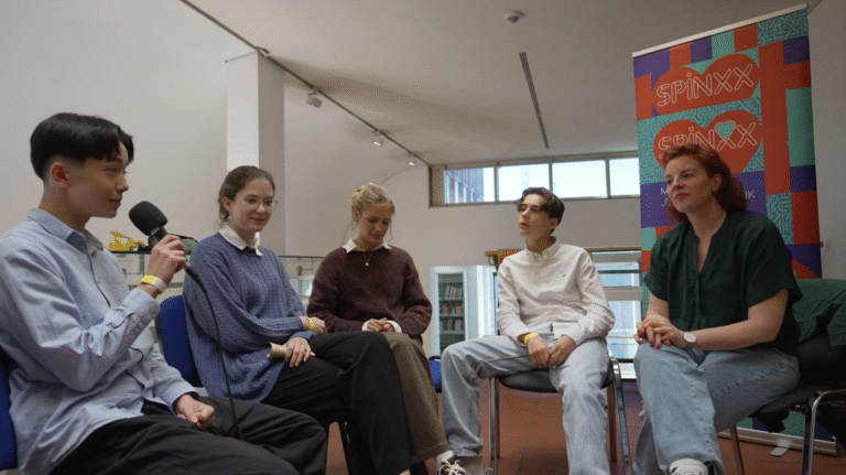 Personen sitzen in einem Kreis und führen ein Interview-Gespräch.